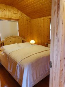 um quarto com uma cama num quarto de madeira em Summerhouse Vaglaskogur em Akureyri