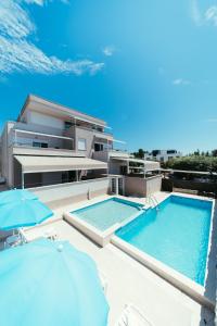 a building with two swimming pools and two umbrellas at Apartments Prestige in Petrcane