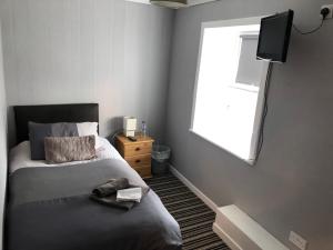a bedroom with a bed with a television and a window at Saracen Head Hotel in Beith