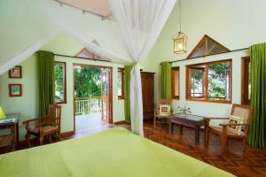 a bedroom with a bed and a table and chairs at Villa Rosa in Kandy