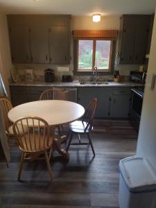 een keuken met een tafel en stoelen en een wastafel bij Ski in/out Spruce Glen Townhomes on Great Eastern Trail in Killington