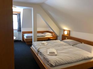 una camera d'albergo con due letti e una scala di Ennstalerhof a Grossraming