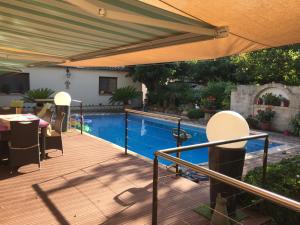 una terraza con piscina y sombrilla en Appartement, avec piscine privative et parking, à 15 minutes à pied du centre ville et à 20 mn de la mer, en Montpellier