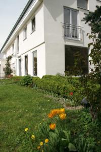 a white house with flowers in the yard at Ferienwohnung Waldvogel in Immenstaad am Bodensee