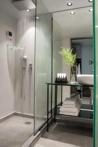 a bathroom with a glass shower and a sink at Athens Utopia Ermou in Athens