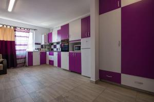 a kitchen with purple and white cabinets in a room at Studio Apartment in Chiajna