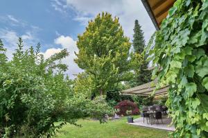 a garden with a table and chairs and trees at Hotel Lindenhof in Kellberg