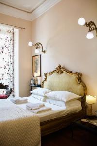a bedroom with a white bed with a gold frame at Twins Apartments in Sanremo