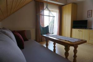 Un dormitorio con una cama y una mesa frente a una ventana. en Haus Waldblick, en Weissensee