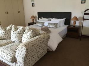 una camera da letto con un letto grande e un divano di Vue Port a Mossel Bay