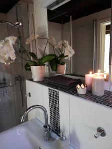 a bathroom with candles and flowers on a counter at FW Achterdeck, 1 Obergeschoss, Petershof-Lehbek in Gelting