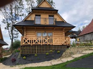 a log cabin with a porch and a balcony at Domek z bali in Murzasichle
