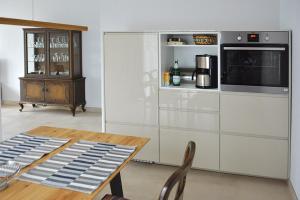 eine Küche mit einem Holztisch und einer Mikrowelle in der Unterkunft Ferienwohnung Elbe in Kurort Gohrisch