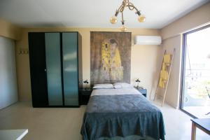 a bedroom with a bed and a painting on the wall at Joanna's studio (Rafina port) in Rafina