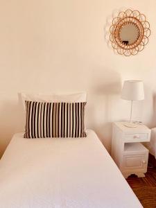 Schlafzimmer mit einem Bett und einem Wandspiegel in der Unterkunft Casas de Mértola - N. Sª das Neves in Mértola