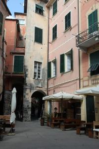 un vicolo con tavoli e ombrelloni di fronte a un edificio di Al nodo di Andrea Cod.Citra 011019-LT-0300 a Monterosso al Mare