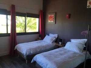 a bedroom with two beds and a window at Gîte au coeur du Ségala in Padiès