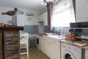 a kitchen with a sink and a washing machine at maisonpetitgasbiganos in Biganos