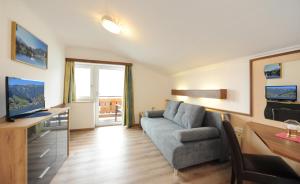 a living room with a couch and a table at Hotel-Garni Seestrand in Zell am See