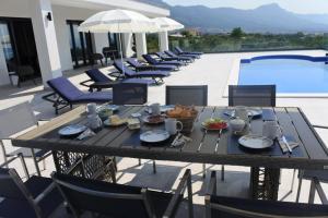 a table with food on it next to a pool at Villa Orao in Kastel Novi