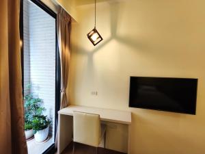 a room with a desk with a tv and a window at Donghae13.8 in Longjing