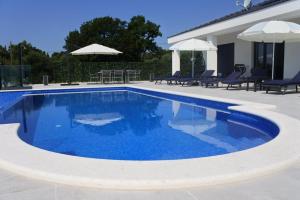 a swimming pool with blue water in a yard at Villa Orao in Kastel Novi