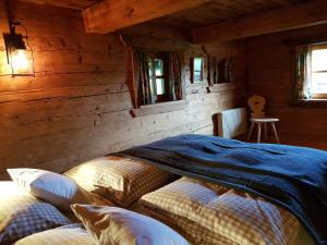 a bedroom with two beds in a log cabin at Ferienbauernhaus Stergut in Weisspriach