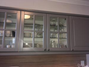 biała szafka ze szklanymi drzwiami z naczyniami w obiekcie Sekt & Wein - Walter Klein w mieście Illmitz