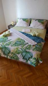 a bed with a green and white comforter on it at Apartman Dora in Šmrika