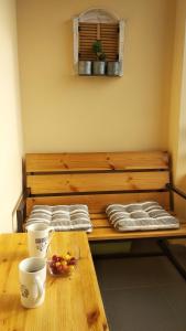 a wooden bench with a table with a bowl of fruit on it at Hillside Apartment Tsaghkadzor in Tsaghkadzor