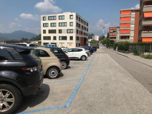 een rij geparkeerde auto's geparkeerd op een parkeerplaats bij Apartment 33A - No Bikes - Self check-in in Lugano