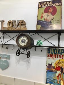 een klok hangend aan een muur naast boeken bij Buda Boutique Apartment in Boedapest
