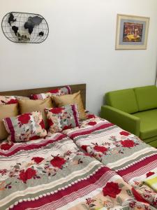 a bed with red and white blankets and a green chair at Buda Boutique Apartment in Budapest