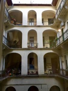 an empty building with balconies and tables and chairs at Buda Boutique Apartment in Budapest