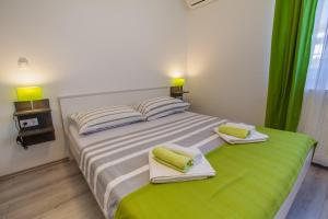 a bedroom with a large bed with towels on it at Room Elelina in Cres