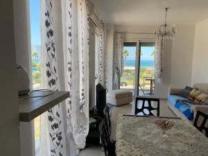 a living room with a table and a view of the ocean at Beachfront Apartment in Orikum