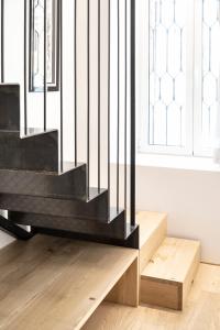 a black staircase in a room with wooden floors and windows at Design Loft Corte Kalister in Trieste