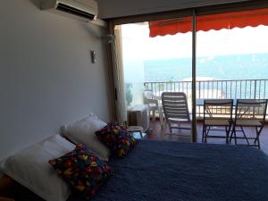 a bedroom with a bed and a balcony with a table and chairs at Antibes: A nest perched on the sea! in Antibes