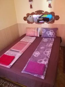 a bed with pink and purple sheets and a mirror at ZА in Khmelʼnytsʼkyy