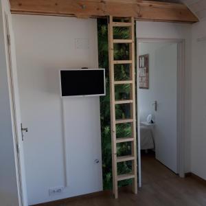 a room with a wall with a tv and a ladder at Ty Breizh in Erdeven