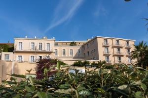 a row of buildings in a city with plants at Résidence Le Beau Rivage in Bandol