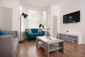 a living room with a blue couch and a table at Flat A - Spacious ground floor, 1 bedroom apartment in Central Southsea, Portsmouth in Portsmouth