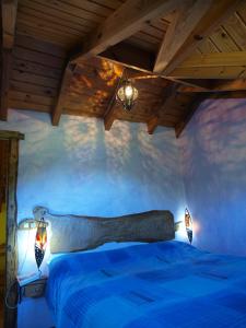 1 dormitorio con 1 cama con cabecero de madera y luces en O´Porron, en Sabiñánigo