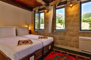 two beds in a room with windows and mountains at Stara Čaršija Hotel & SPA in Bar +88 photos