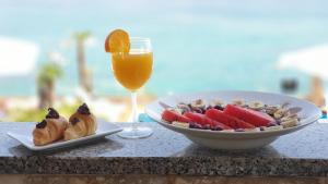 a table with a plate of food and a glass of orange juice at Hotel Plaza in Pag