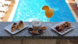 a table with plates of food and a glass of orange juice at Hotel Plaza in Pag