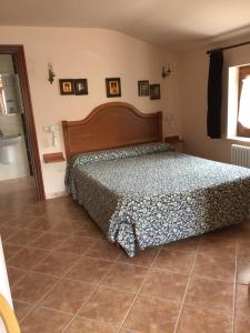 sypialnia z łóżkiem i podłogą wyłożoną kafelkami w obiekcie Posada El Urogallo en el Valle de Cabuérniga w mieście Renedo