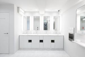 - une salle de bains blanche avec deux lavabos et deux miroirs dans l'établissement TSUKIMI HOTEL, à Kyoto