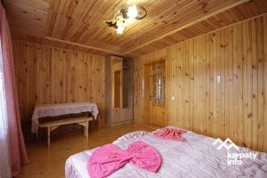 микуличин на долоні في ميكوليتشن: غرفة نوم عليها سرير وملابس وردية