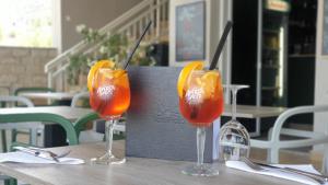 two glasses with fruit in them sitting on a table at Hotel Plaza in Pag